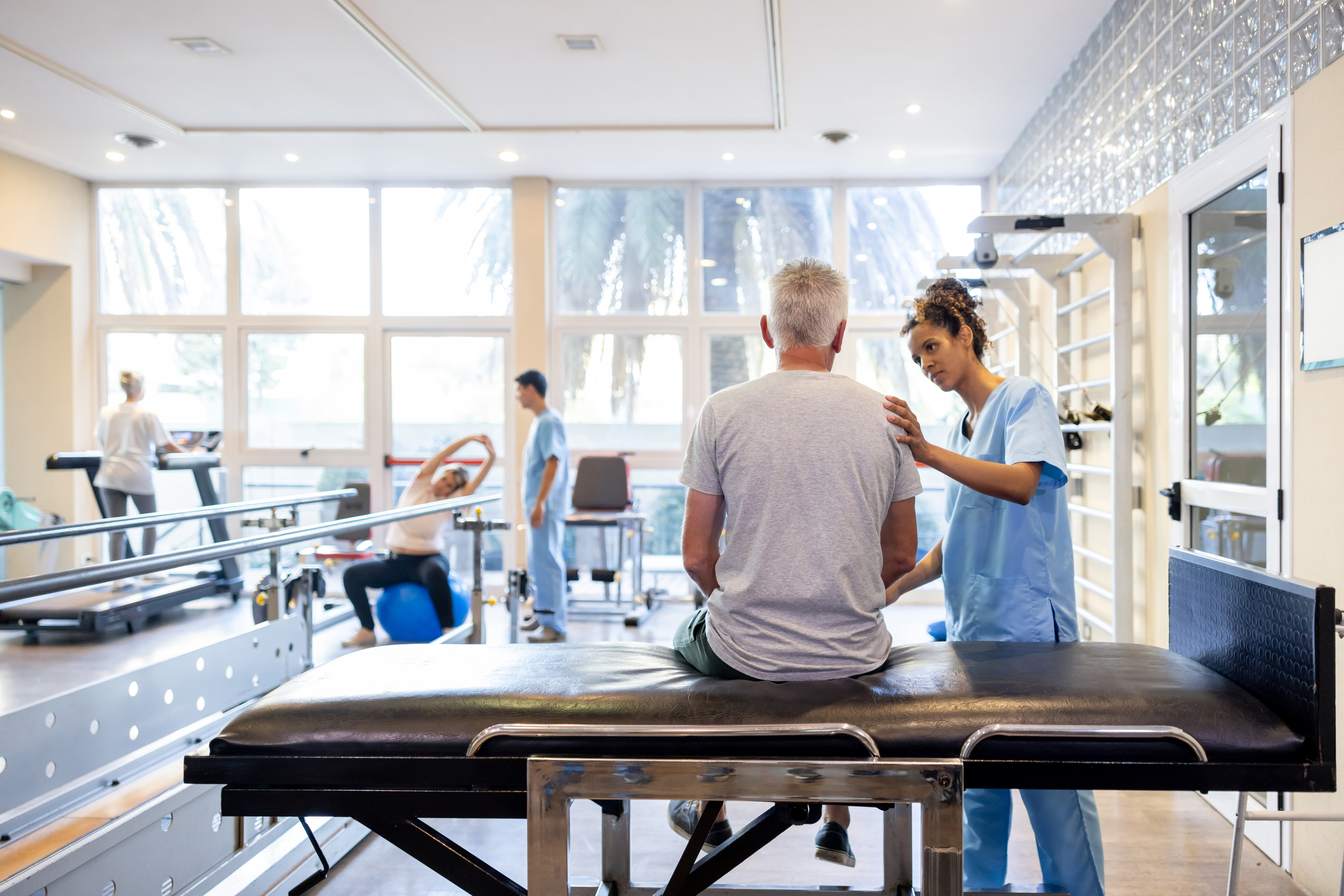 Physical therapist working with patient in a bright modern rehabilitation clinic